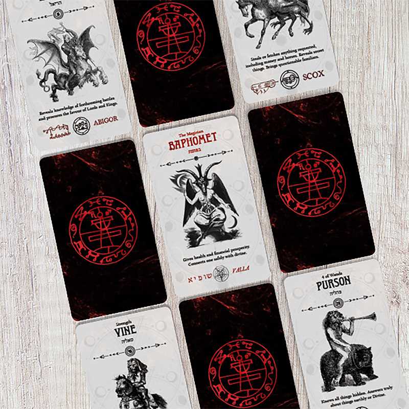 Collection of tarot cards with black and red designs on a wooden surface
