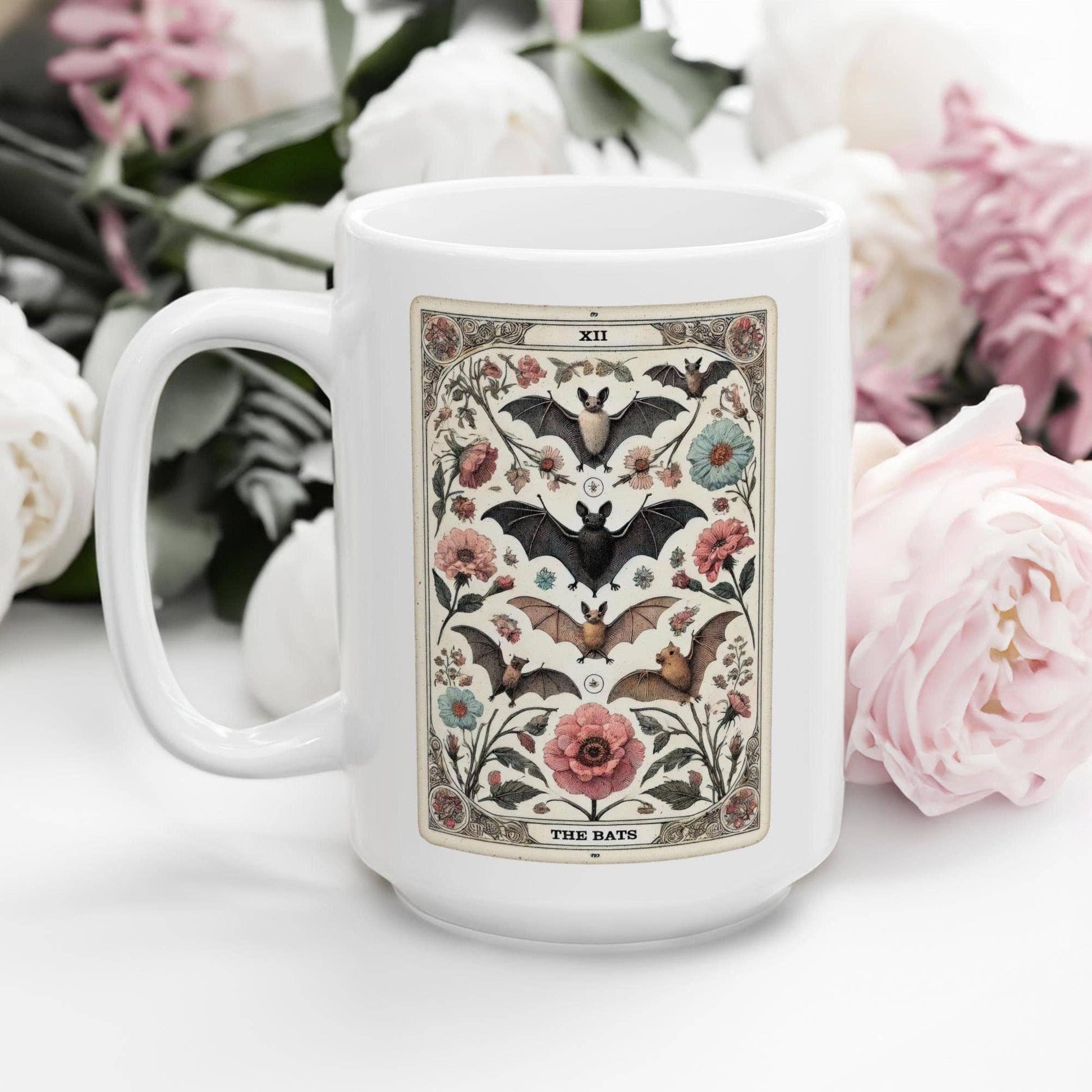White mug with bat and floral design on a white surface with flowers in the background