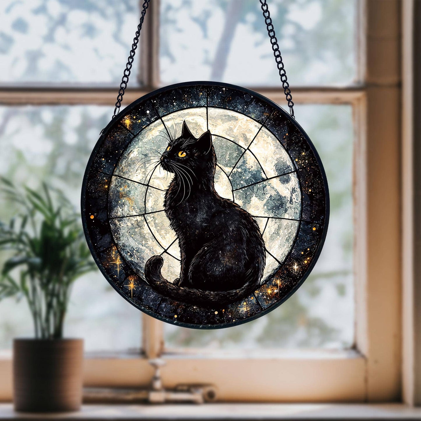 Decorative roundel with a black cat design hanging in front of a window.