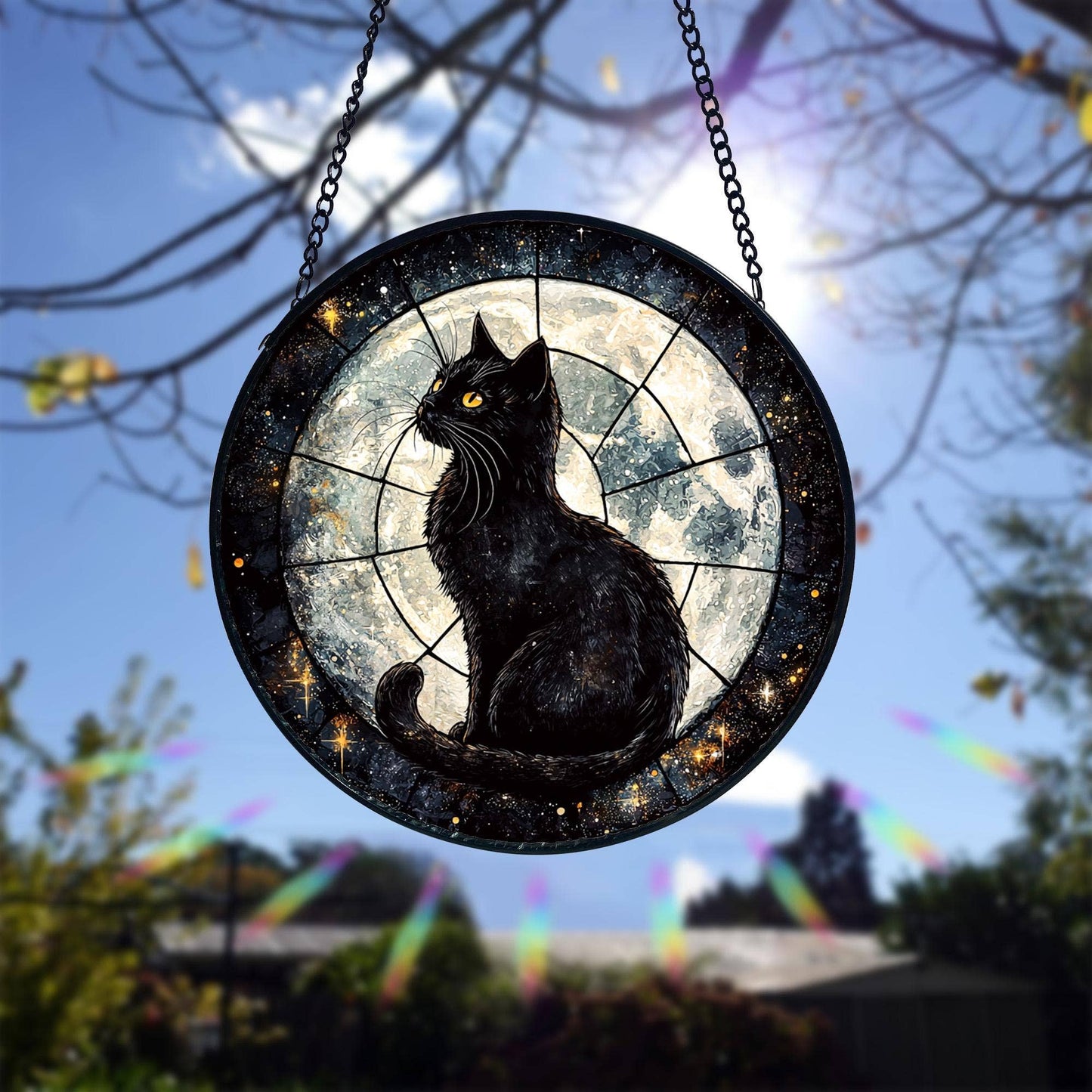 Decorative glass panel with a black cat silhouette against a moonlit sky, hanging outdoors.