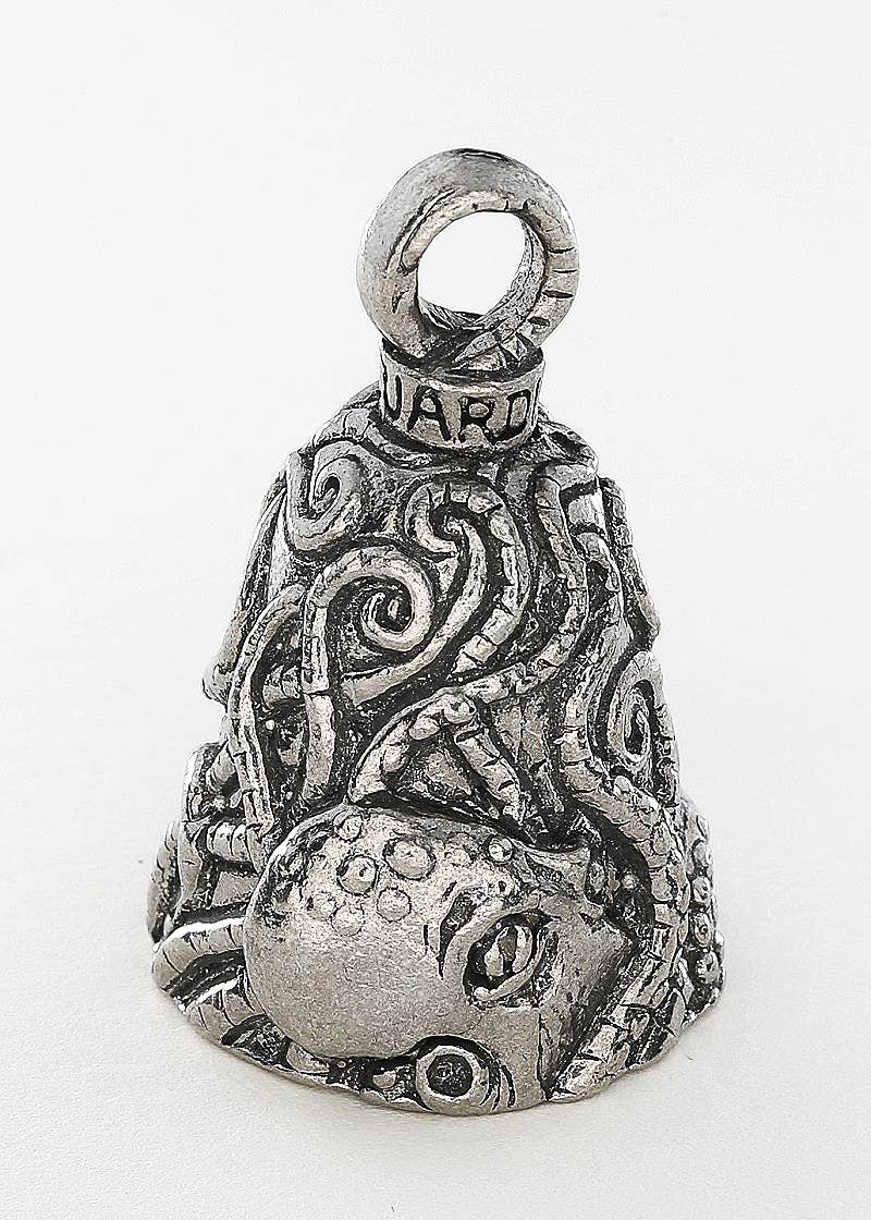 Decorative silver bell with intricate designs on a white background