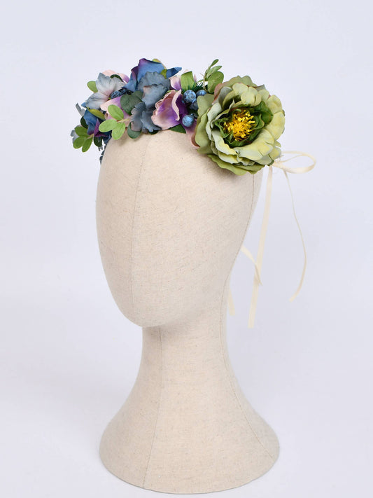 Floral headband on a mannequin head against a white background