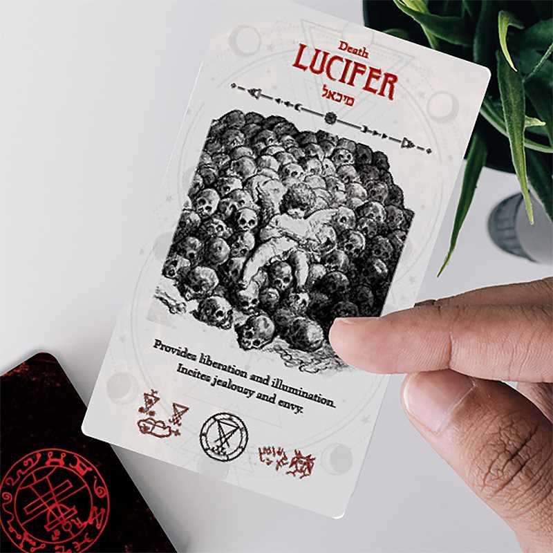 Card featuring 'Lucifer' with black and white illustration and text, held by a hand.